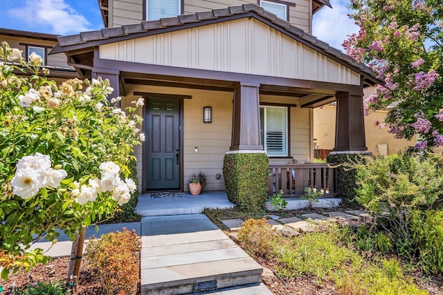 doorway to property featuring board and batten siding and a porch