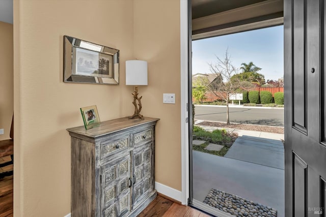 foyer entrance with baseboards and wood finished floors
