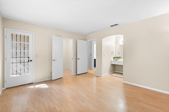 unfurnished bedroom with baseboards, light wood-type flooring, and visible vents
