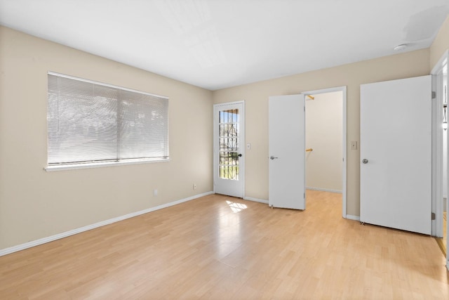 interior space with baseboards and light wood finished floors