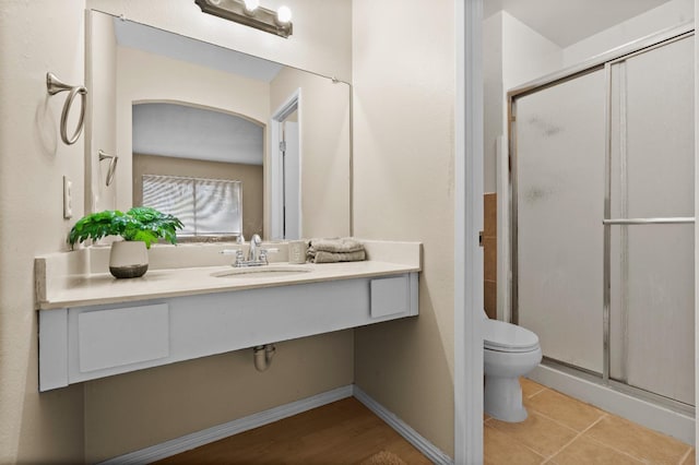bathroom with vanity, tile patterned flooring, a shower stall, and toilet