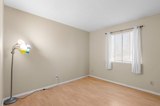empty room featuring baseboards and light wood-style floors