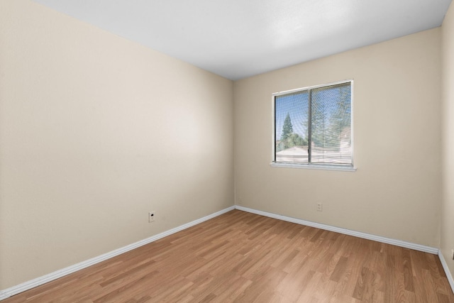 unfurnished room featuring baseboards and light wood finished floors