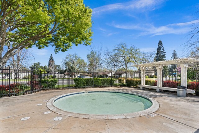 view of swimming pool featuring fence and a pergola
