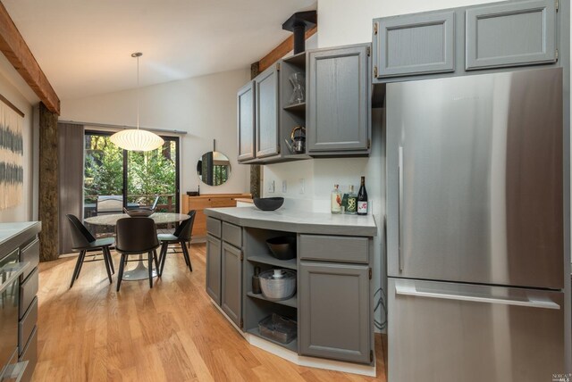 kitchen with gray cabinetry, open shelves, and freestanding refrigerator