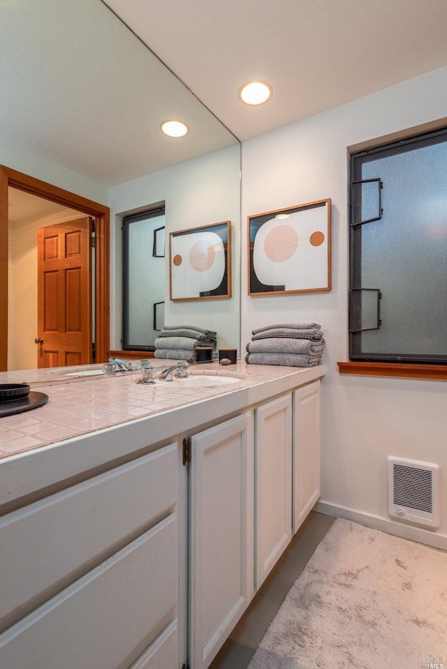 bathroom featuring vanity, baseboards, recessed lighting, and visible vents