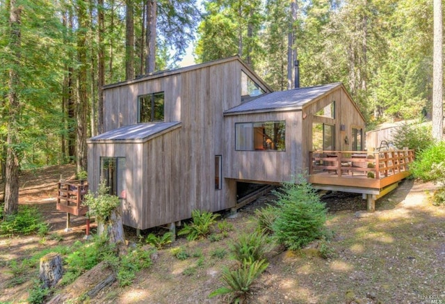 rear view of house featuring a wooden deck
