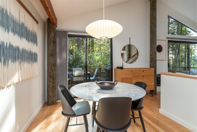 dining area featuring a wealth of natural light, vaulted ceiling, light wood-style floors, and baseboards