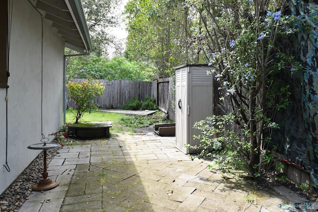 view of patio featuring a fenced backyard, an outbuilding, and a shed