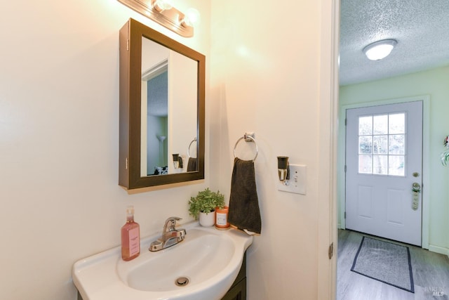 bathroom with a textured ceiling, wood finished floors, and vanity