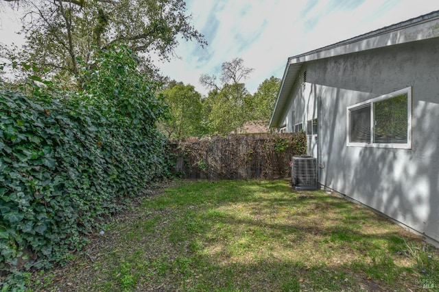 view of yard featuring cooling unit and fence