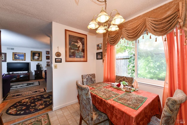 dining area featuring baseboards, a textured ceiling, visible vents, and a chandelier
