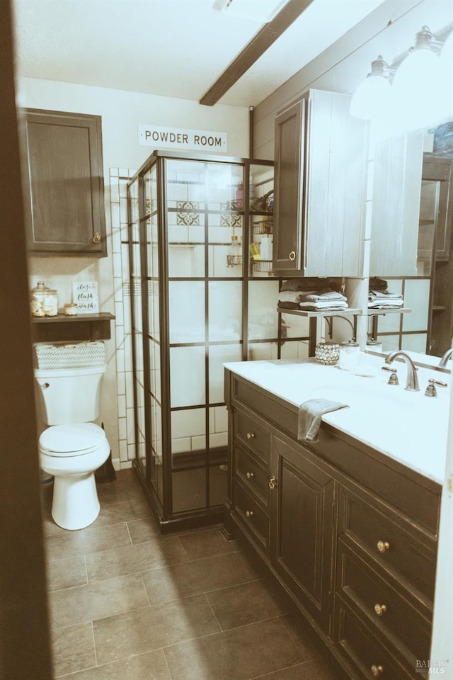 full bath with toilet, vanity, a shower stall, and tile patterned flooring