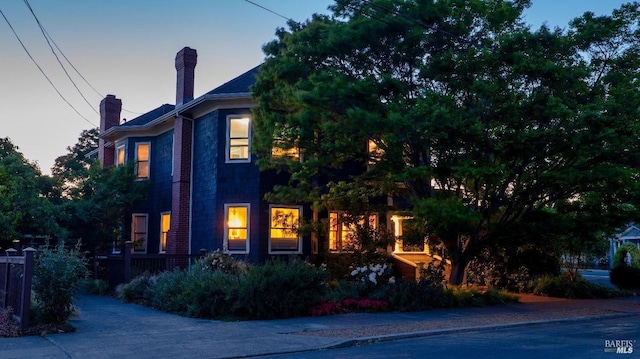 property exterior at dusk with a chimney