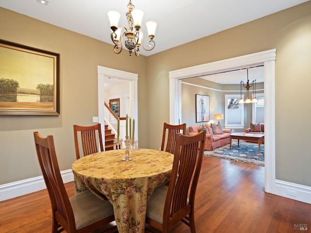dining area with baseboards, dark wood finished floors, and a notable chandelier