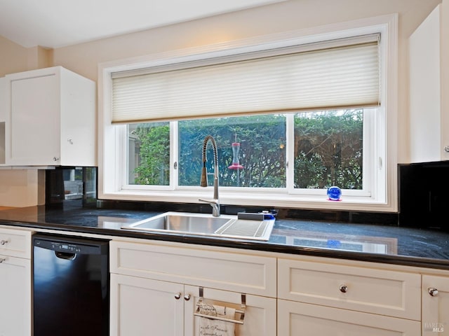 kitchen with dark countertops, a wealth of natural light, a sink, and dishwasher