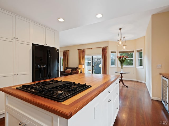 kitchen with white cabinets, butcher block counters, and black appliances