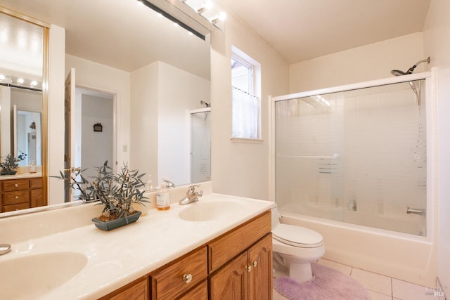 full bathroom featuring double vanity, a sink, toilet, and tile patterned flooring