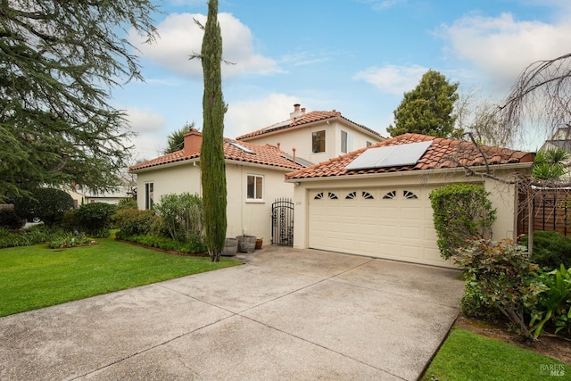 view of side of property featuring stucco siding, an attached garage, roof mounted solar panels, driveway, and a lawn