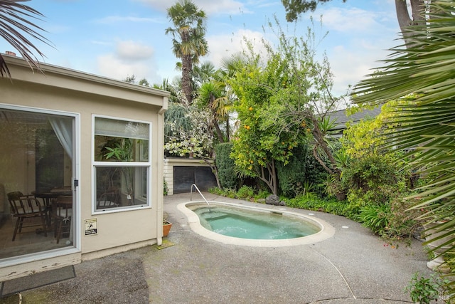 view of pool featuring a jacuzzi and a patio area