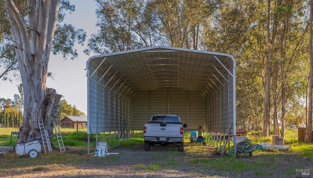 view of parking / parking lot with a detached carport and dirt driveway