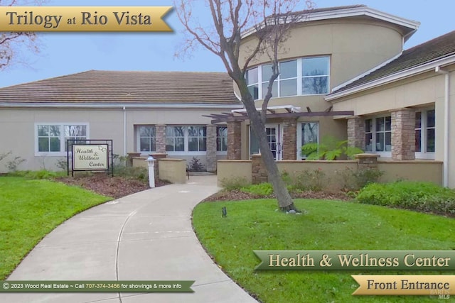 321 Riverwood Ln, Rio Vista, CA 94571 - view of front of property featuring stone siding, stucco siding, a front lawn, and a tile roof