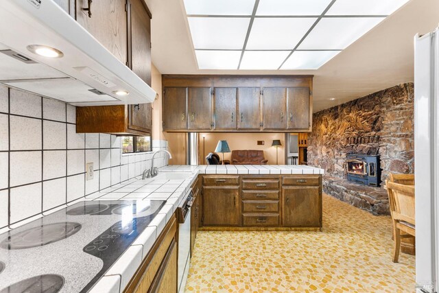 2062 Woolsey Rd, Fulton, CA 95439 - kitchen with a sink, a wood stove, a peninsula, under cabinet range hood, and tile countertops
