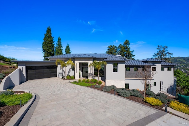 contemporary house featuring stucco siding, metal roof, and a standing seam roof