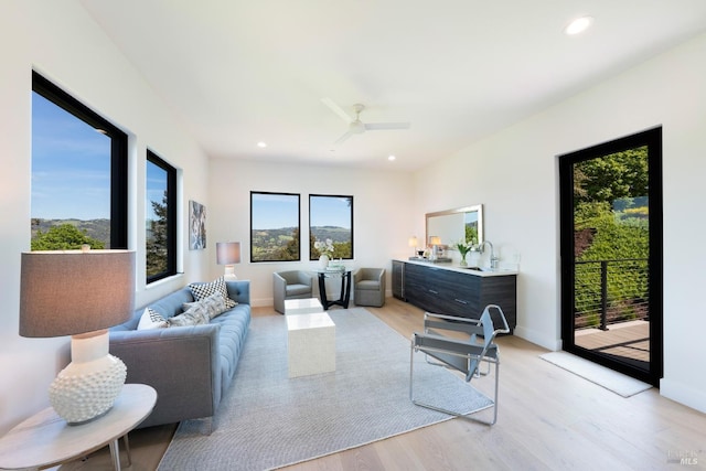 living area with baseboards, recessed lighting, and light wood-style floors
