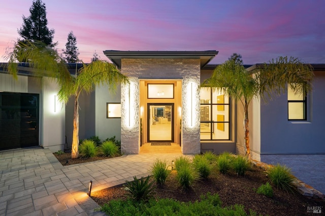 exterior entry at dusk with stucco siding