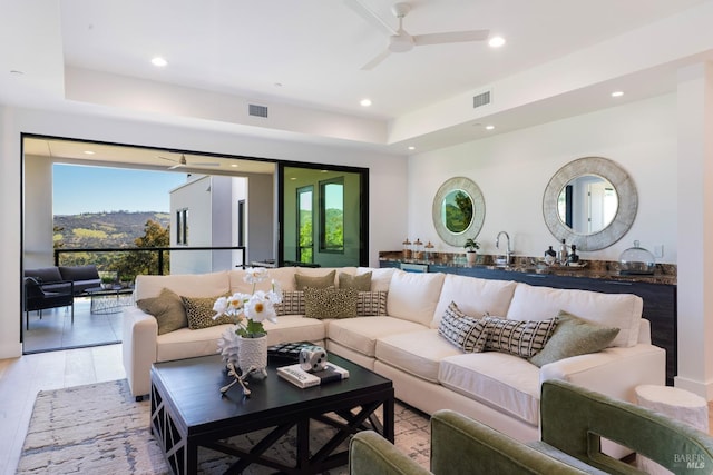 living area featuring light wood finished floors, recessed lighting, ceiling fan, and visible vents