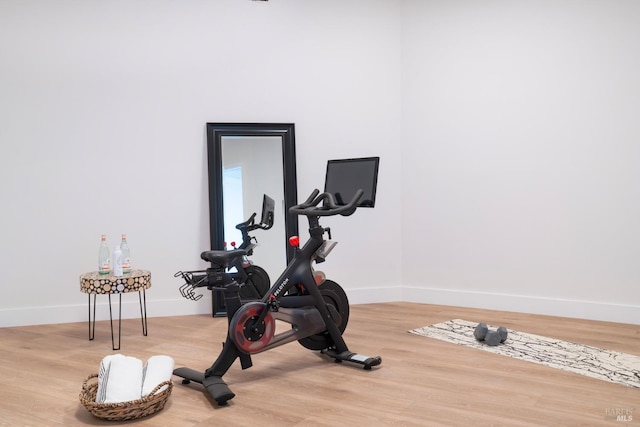 workout room featuring baseboards and wood finished floors