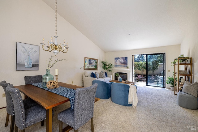 dining area with carpet floors, lofted ceiling, a glass covered fireplace, and a notable chandelier
