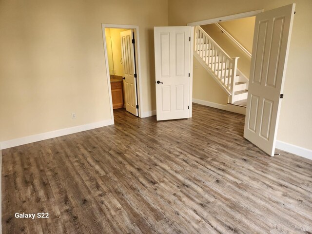 unfurnished room featuring baseboards and dark wood-style flooring
