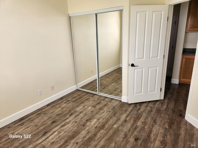 spare room featuring french doors, baseboards, and dark wood-style flooring