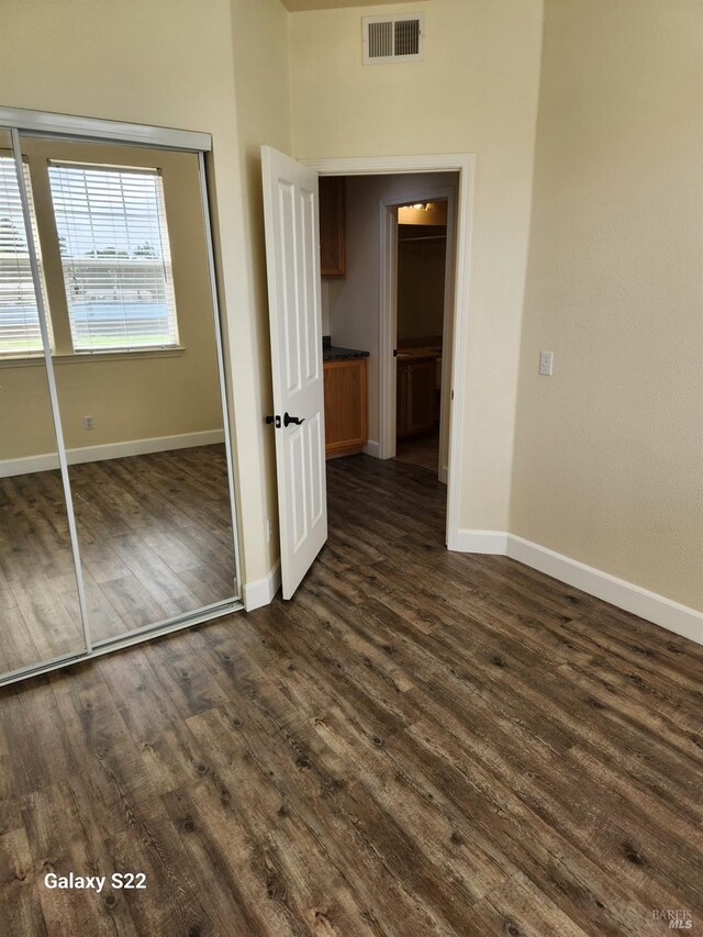empty room with french doors, baseboards, and dark wood finished floors