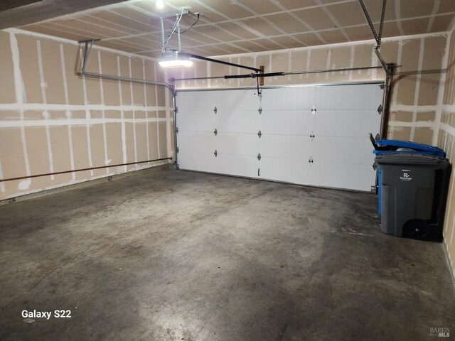 garage with water heater and a garage door opener