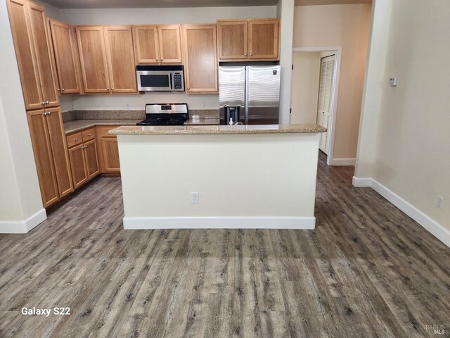 unfurnished room featuring baseboards and dark wood-style flooring