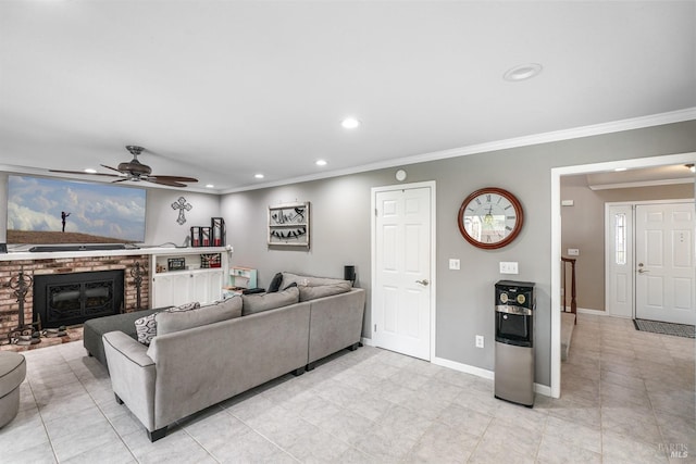 living room with a brick fireplace, baseboards, ornamental molding, recessed lighting, and a ceiling fan