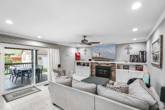 living area featuring a ceiling fan, recessed lighting, ornamental molding, and a brick fireplace