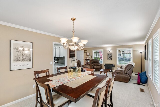 carpeted dining room with baseboards, visible vents, ornamental molding, and an inviting chandelier