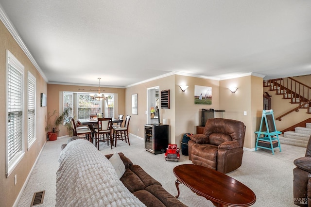 living area featuring carpet flooring, visible vents, stairway, and a notable chandelier