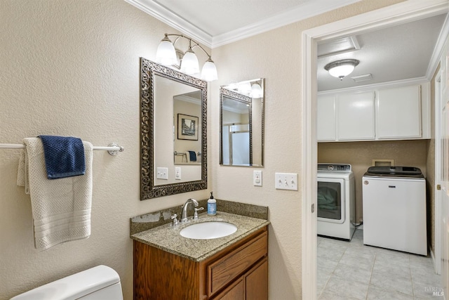 bathroom with a textured wall, crown molding, toilet, and washer and dryer