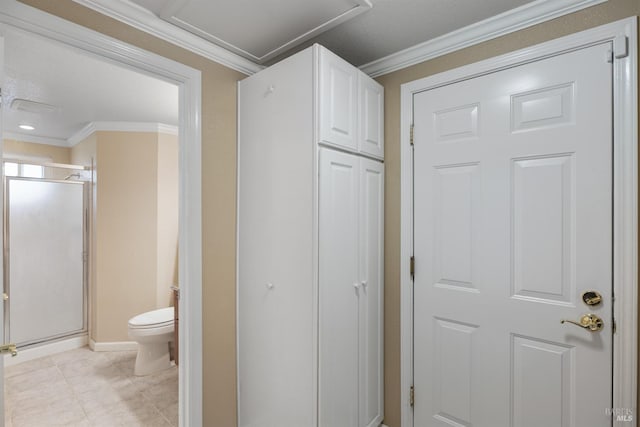 bathroom featuring tile patterned flooring, toilet, ornamental molding, baseboards, and a shower stall
