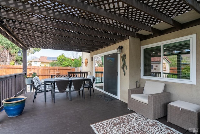 view of patio with a wooden deck, a pergola, fence, and outdoor dining space