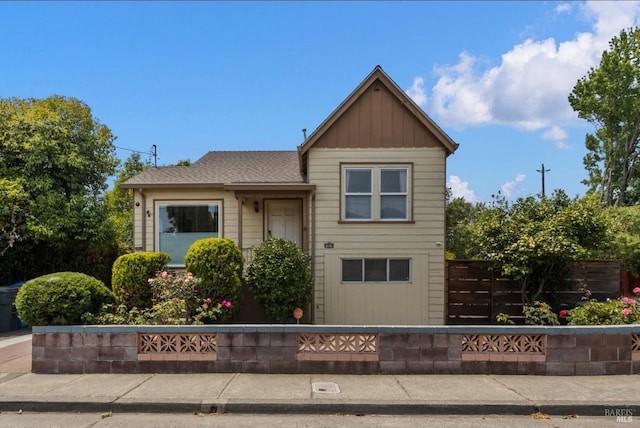 view of front of home featuring fence and a shingled roof