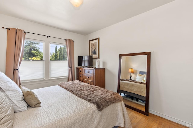 bedroom with light wood-style flooring and baseboards