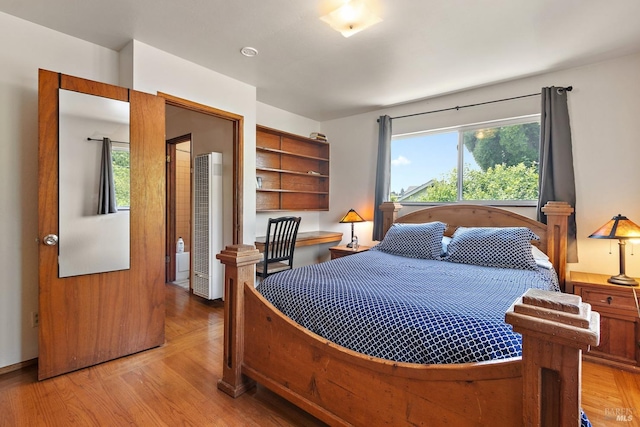 bedroom featuring light wood finished floors and multiple windows