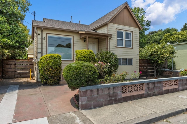 view of front of house with fence and a shingled roof