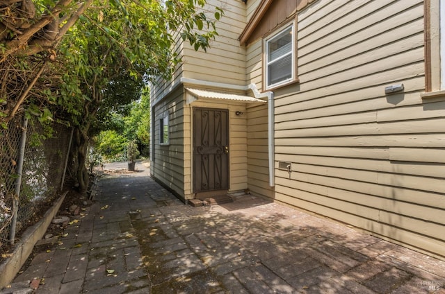 view of exterior entry featuring a patio area